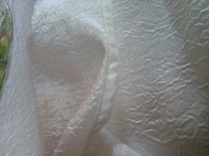 Nappe rond en taffetas de couleur ivoire satinée vue de très près